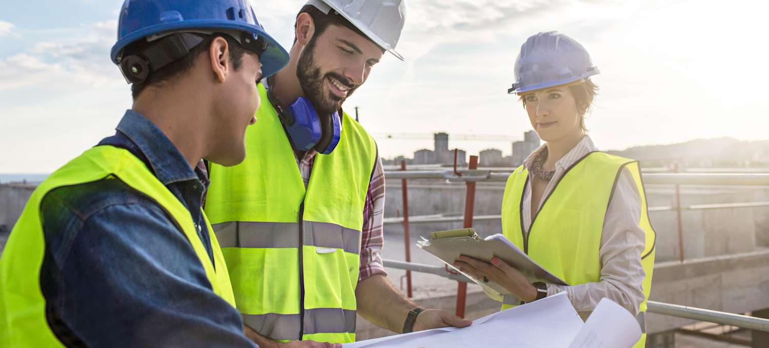Construction-workers-and-architect-looking-at-blueprints-on-construction-site-514311930_5413x3609__1_